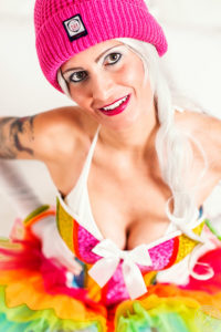A blond young partygirl wearing her sexy gogo dancer outfit at home. A little bit upskirt at the kitchen with a panty and colorful overknees